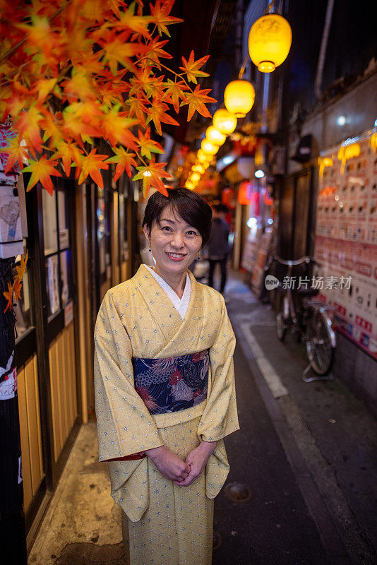 身着和服的日本妇女在秋天参观日本居酒屋巷子