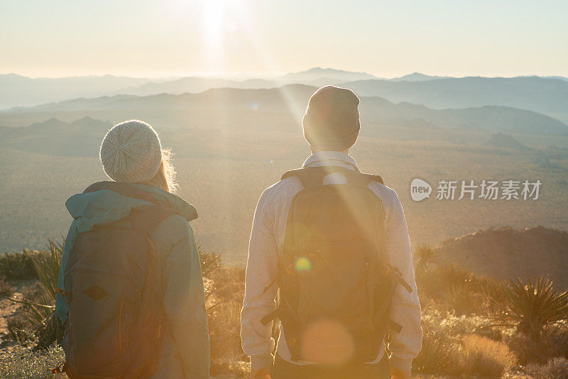 一对夫妇在日出时从山顶眺望风景