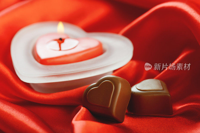 红色丝绸，心形蜡烛和巧克力