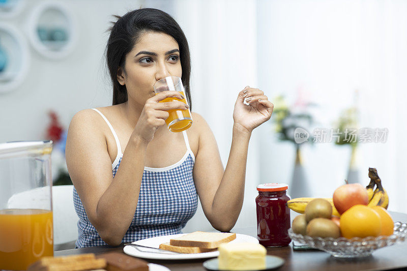 年轻妇女吃早餐的照片