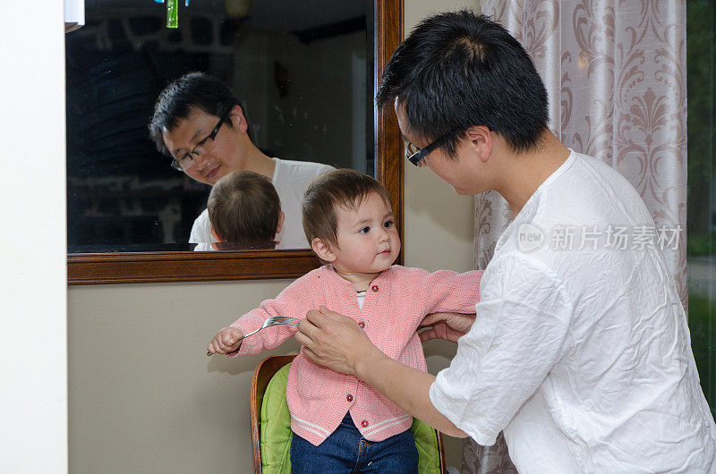 一位中国父亲在晚饭后清理他的混血女婴