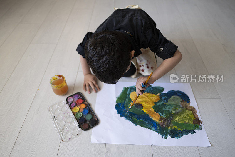 快乐的小婴儿艺术家在家里用彩色颜料画画