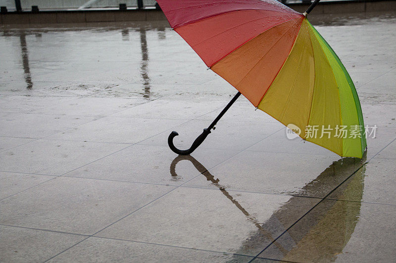 雨点落在彩虹伞上，天以自然为背景