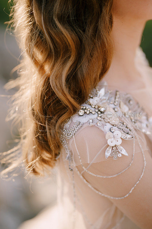 新娘穿着亮片和珠饰薄纱礼服。特写镜头