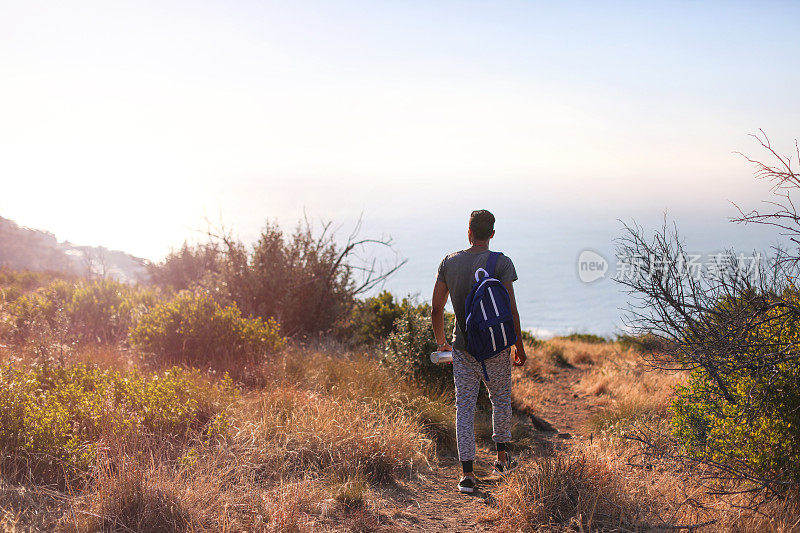 一名年轻男子在南非开普敦的信号山上徒步旅行。