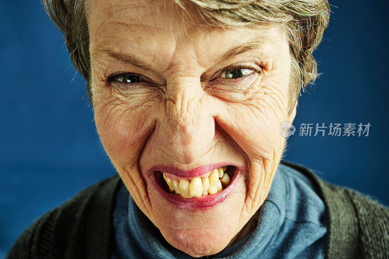 一位老妇人露出牙齿看着镜头