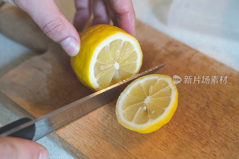 一个女人在厨房的木板上切柠檬