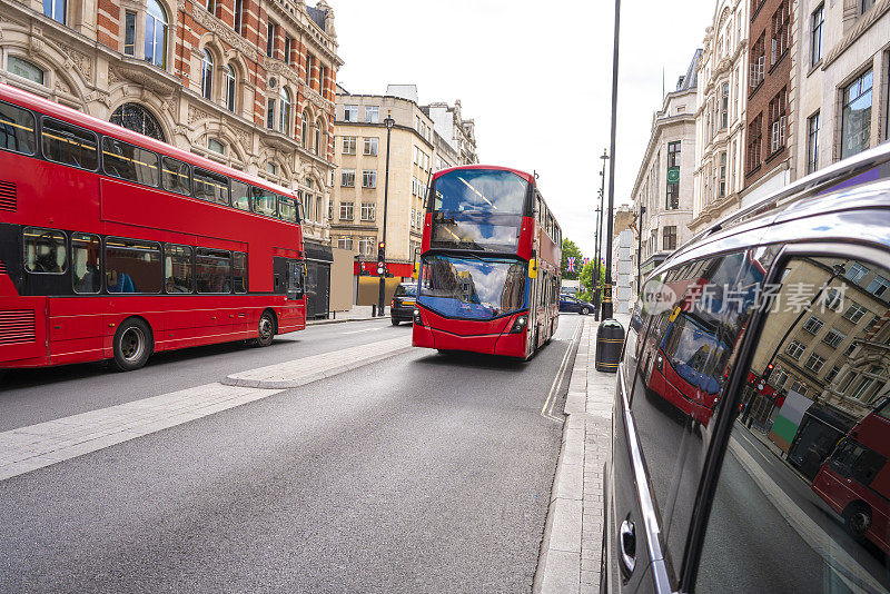 伦敦牛津街有红色巴士和伦敦出租车，人们走在街上