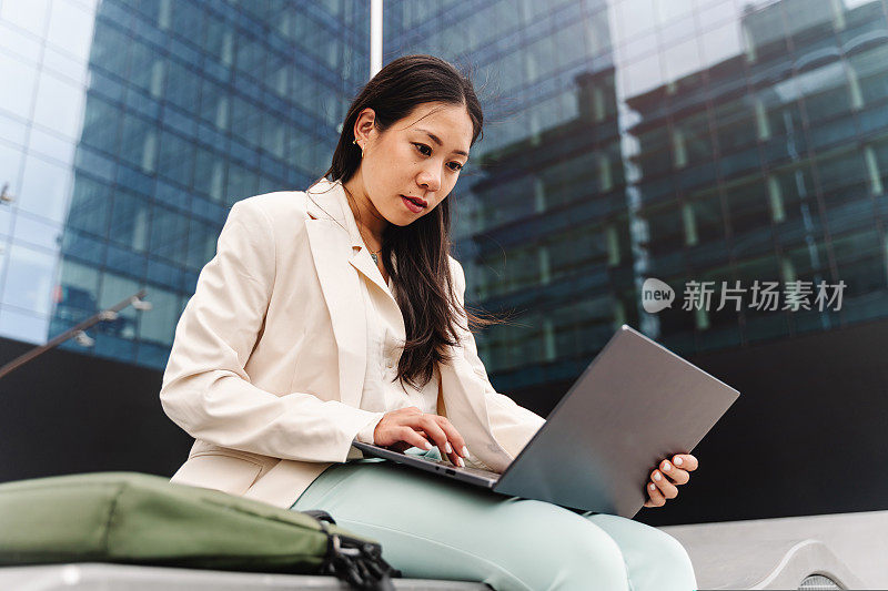 年轻的亚洲职业商业女性在办公室外使用笔记本电脑工作-女性的灵感和抱负