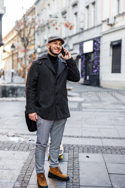 一个年轻人走在城区里讲手机。