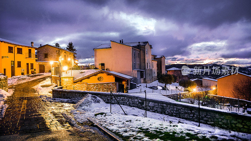 翁布里亚(Umbria)一个中世纪村庄的积雪小巷，夜晚的冬日氛围