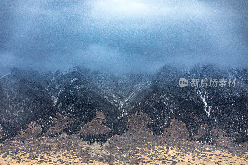 戏剧性的风暴云和雨在雪山上移动