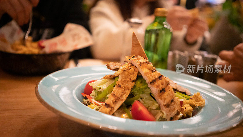 鸡肉沙拉在餐厅平摊的白色盘子里