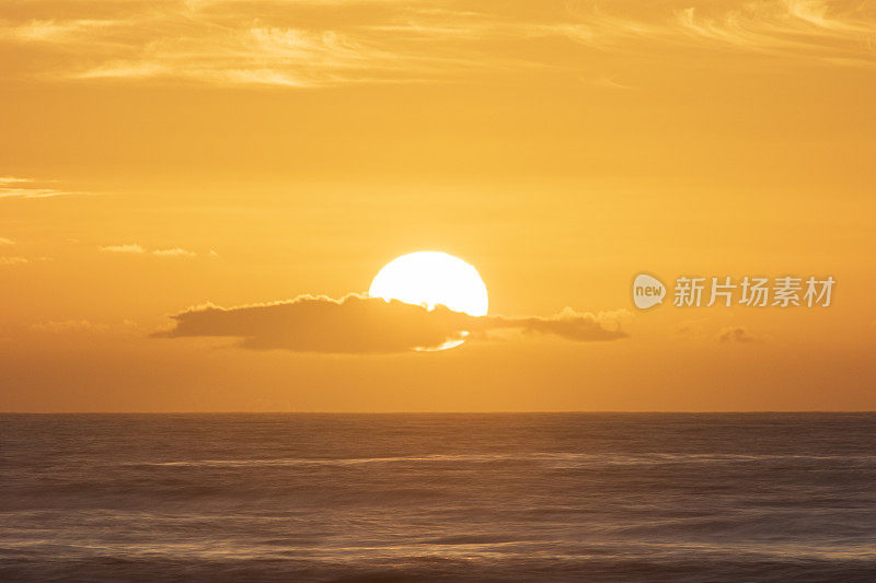 金色的太阳在平静黑暗的海面上冉冉升起