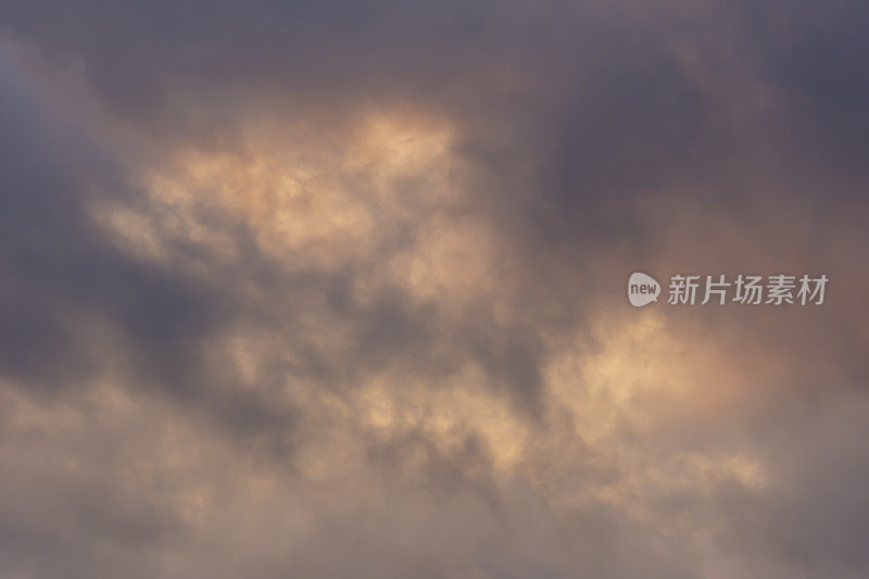 在多云的天空中，明亮的色调冲破黎明灰色的云层