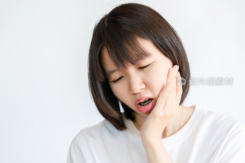 牙痛的女人捂着脸颊。