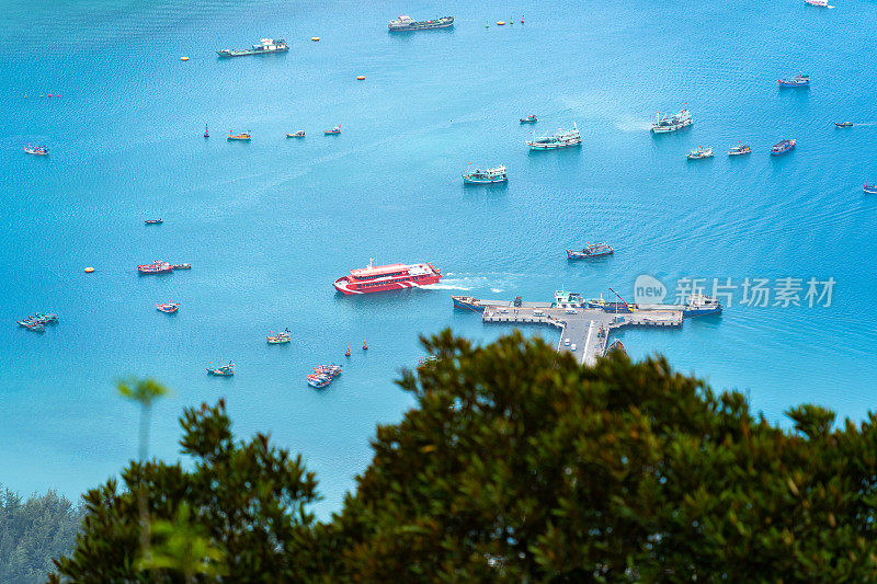 越南孔岛本丹港，湛蓝的大海，蓝天山和五颜六色的船只。