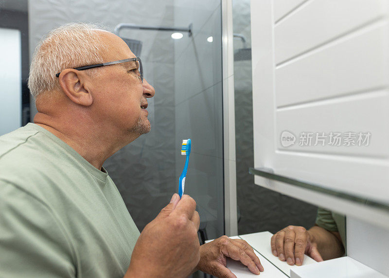 成熟男人在浴室镜子前刷牙