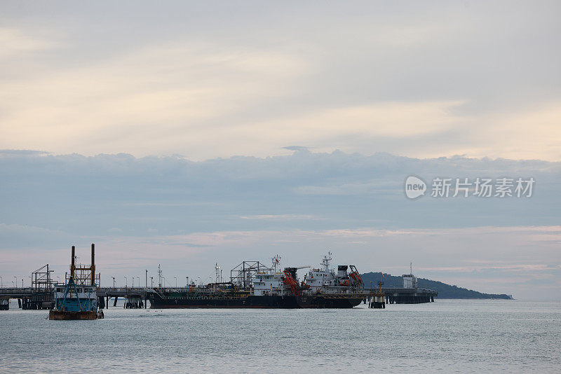 傍晚在港口、海上、河码头。工业起重机的轮廓。港口风景。明亮的夕阳，剪影动力起重机在海港，进出口的概念。