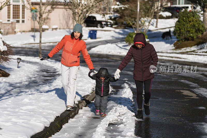 几代同堂的一家人在雪地里散步