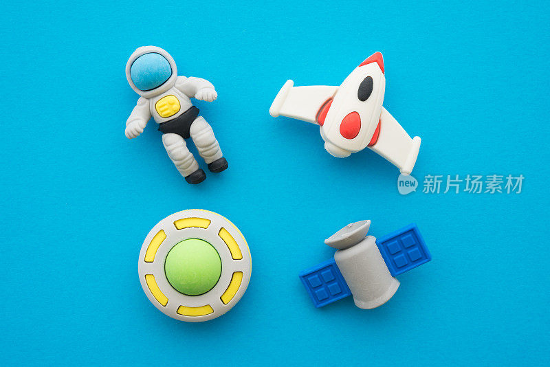扁平的可爱的宇航员，火箭，卫星和不明飞行物外层空间橡皮玩具集在蓝色的背景。