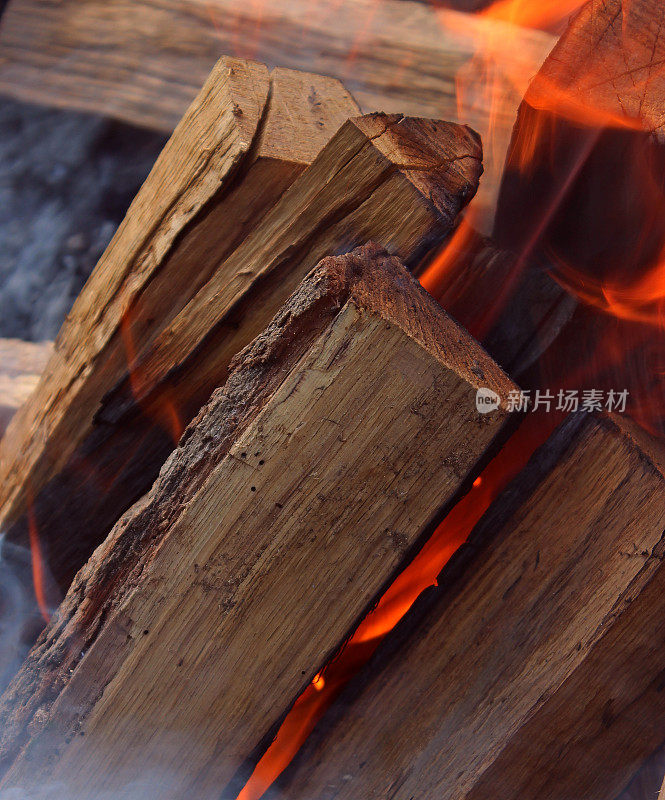 燃烧的原木堆叠在燃烧的篝火详细库存照片