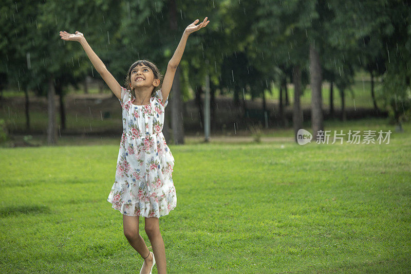 小女孩在公园享受降雨