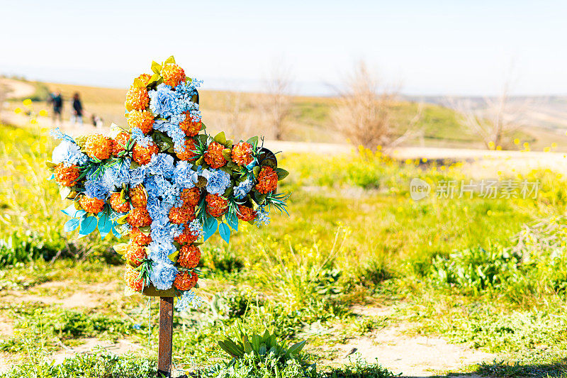 令人印象深刻的十字架精心建造，只有五颜六色的花朵。在路边的一块地里。西班牙
