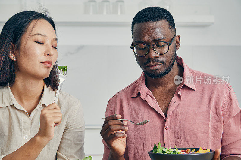 品味每一口的爱。幸福的夫妇享受着早午餐