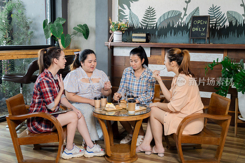 一群自由创意的女员工在休闲愉快地度过午餐后的空闲时间在咖啡馆，女工或年轻的企业主在小餐馆交谈或会议生活方式
