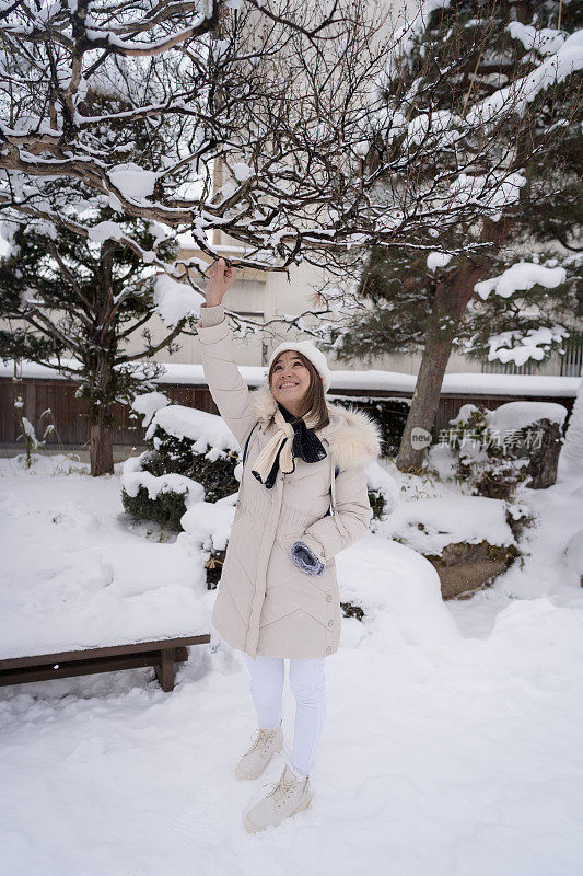 美丽的女游客享受他们的日本之旅在雪的冬天