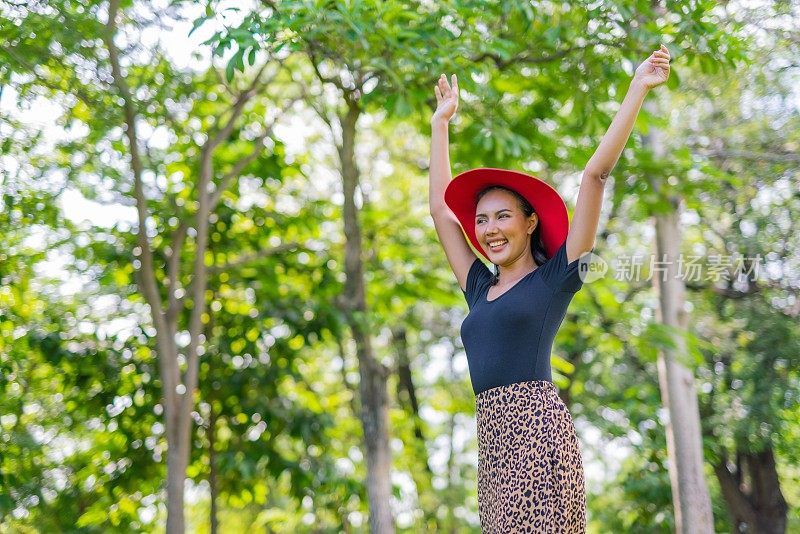 一个美丽和好看的年轻亚洲女性模特女士穿着夏天寒冷的裙子在公园