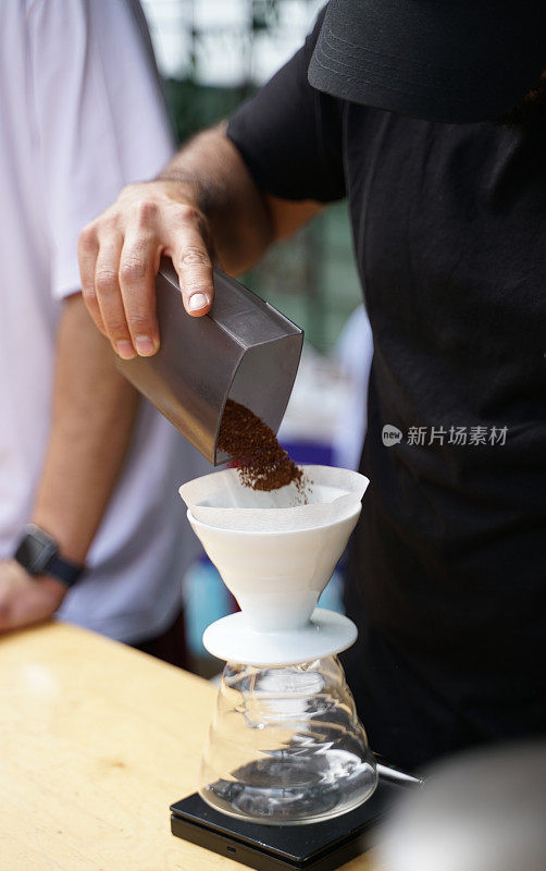 咖啡师把磨碎的咖啡豆在v60过滤器准备过滤咖啡