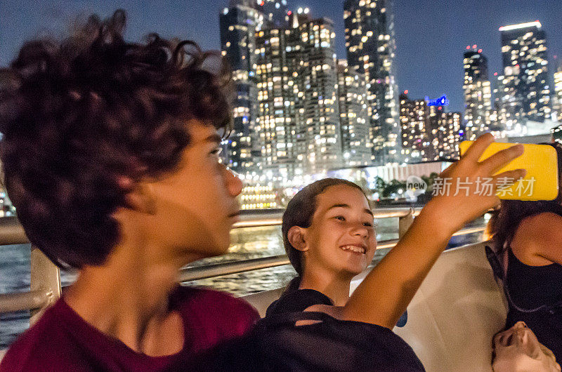 十几岁的女孩在晚上与纽约摩天大楼自拍