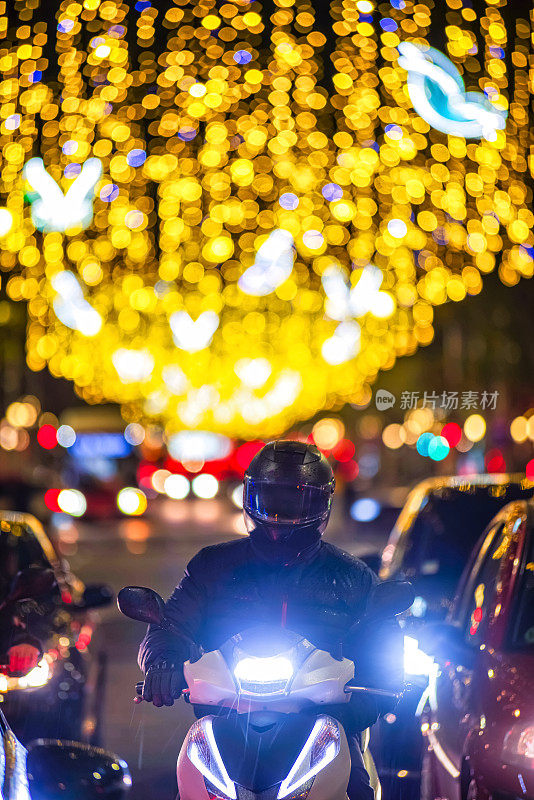 汽车和摩托车在高峰期，晚上的交通和圣诞彩灯