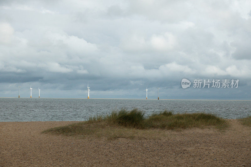 从诺福克郡的海滩看向远处的风力涡轮机。环保省电，为什么不喜欢。