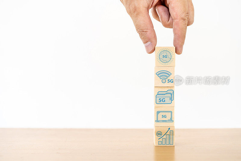 商人手持木方块和图标符号，以5G网络高速移动互联网新时代网络，混合媒体，全球业务