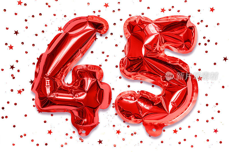 气球的数字由红色箔纸制成，数字45在白色的背景上有亮片。印有铭文的生日贺卡。周年的概念。