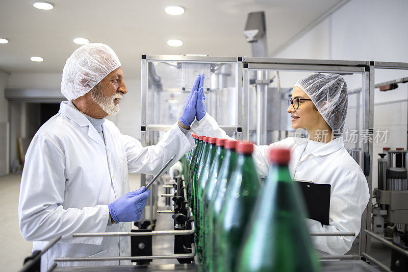在装瓶厂内，工人们为成功生产水和PET包装击掌致意。