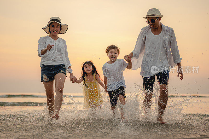 快乐的亚洲家庭在日落的海滩上玩海。享受野餐的家人。家庭，旅行，海滩，放松，生活方式，度假概念。