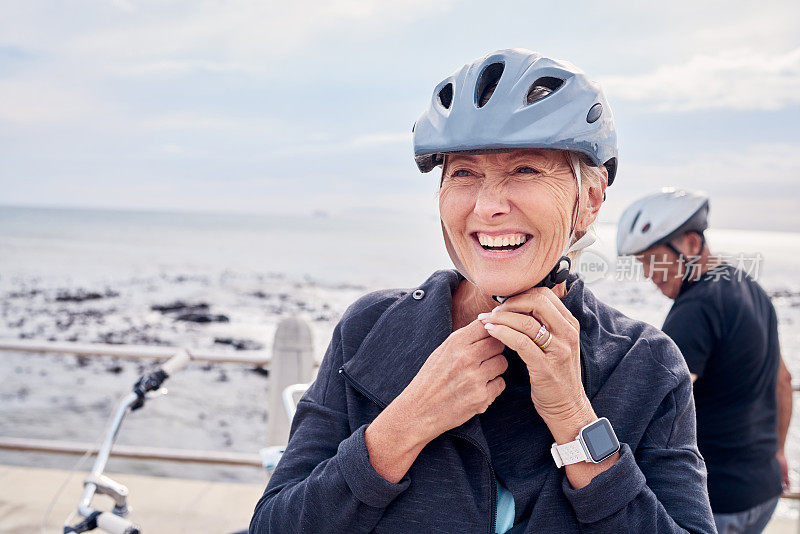 快乐的老妇人，带着自行车和头盔在沙滩上度假，和男人一起健身。笑容满面，幸福健康，澳洲海洋度假成熟夫妇自行车运动。