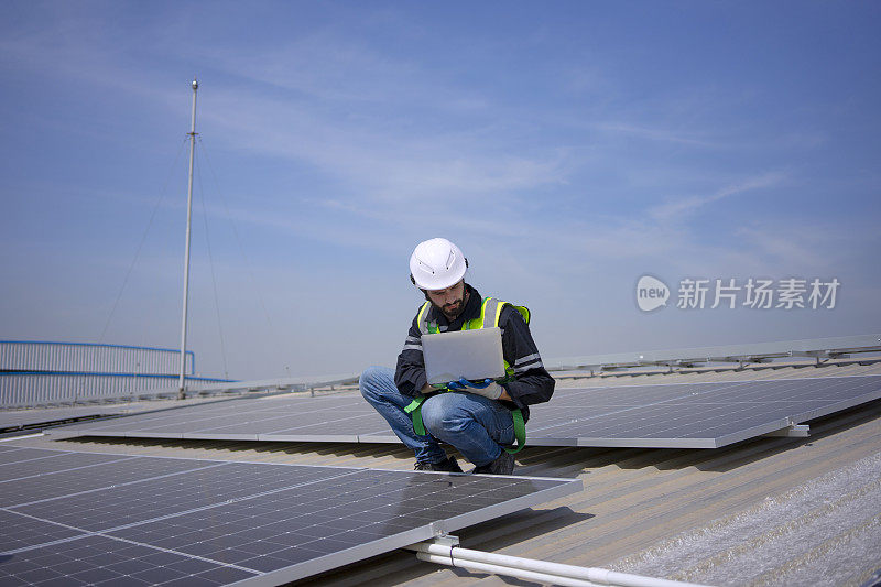 蓝领工人在屋顶安装太阳能电池板。