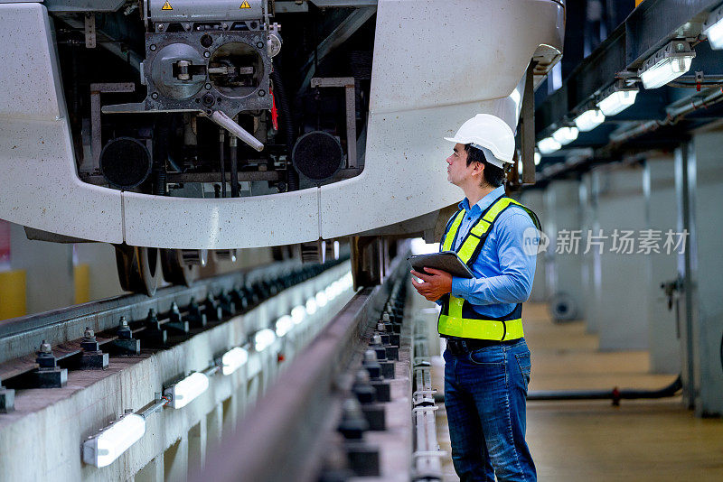 专业工程师在工厂工作场所拿着平板电脑检查或维护电气或地铁前部。