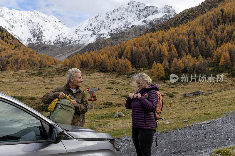 成熟的徒步旅行者把车停在山间草地上