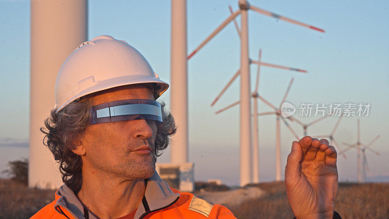 戴着VR眼镜的工程师在风电场工作。AR工具概念。