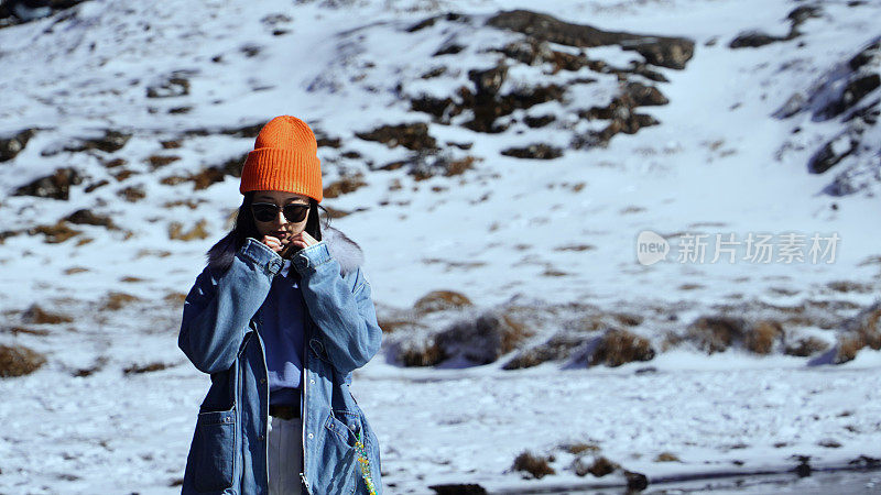 一个女人在寒冷的天气里穿行于白雪覆盖的山林之中