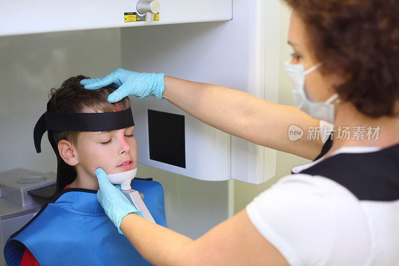 牙医在面具准备男孩颌骨x光成像