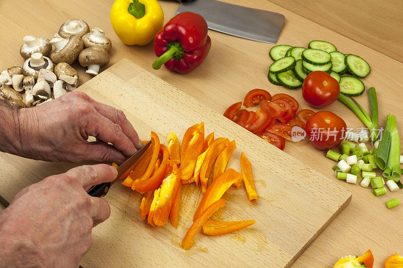 这是一位厨师用手切黄辣椒的特写