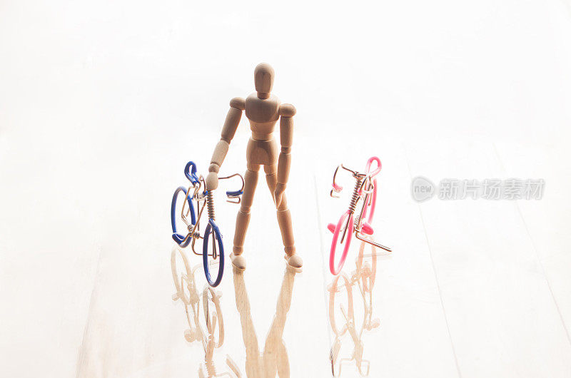 概念木制人偶和自行车隔离白色背景反射。
