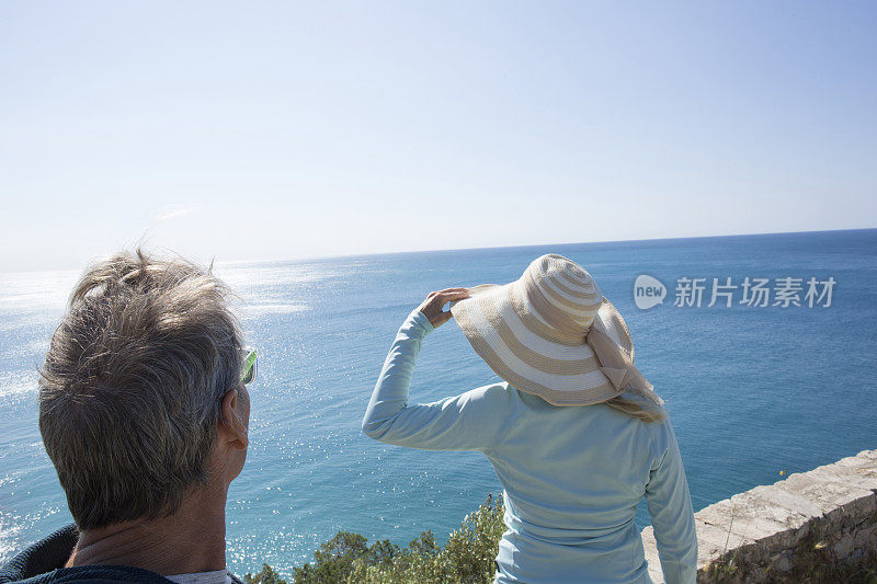 一对夫妇眺望意大利利古里亚的地中海海岸线。